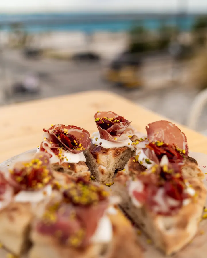 Pizza al padellino con capocollo, pomodorini secchi e granella di pistacchio