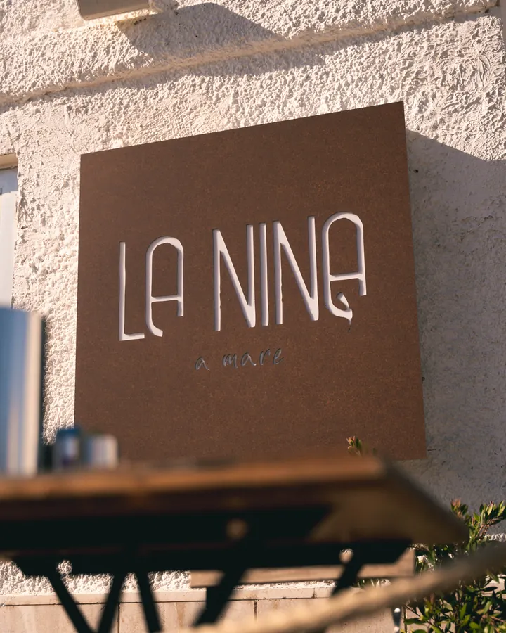 L’insegna La Nina sul muro bianco del locale
